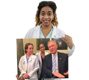 Student holding photo of students with Tim Kaine